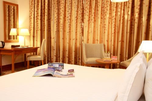 a hotel room with a bed with a book on it at Sai Gon Dong Ha Hotel - a member of Saigontourist Group in Quảng Trị