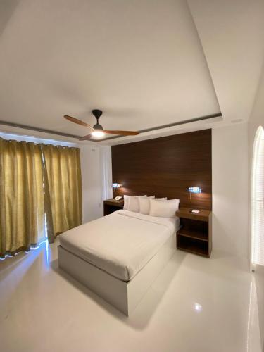 a bedroom with a bed and a ceiling fan at Buena Casa Hotel in Olongapo