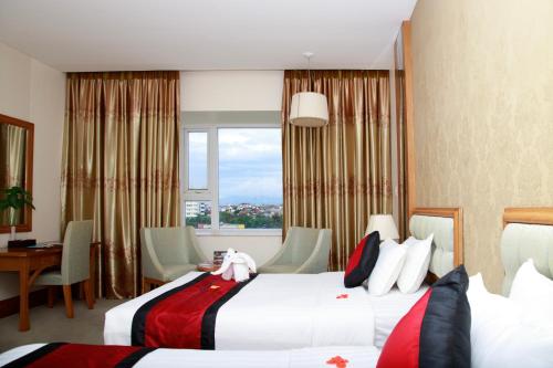a hotel room with two beds and a window at Sai Gon Dong Ha Hotel - a member of Saigontourist Group in Quảng Trị