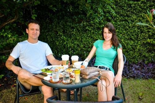 a man and a woman sitting at a table with food at The Choice Hotel - Adults Only in Bangkok