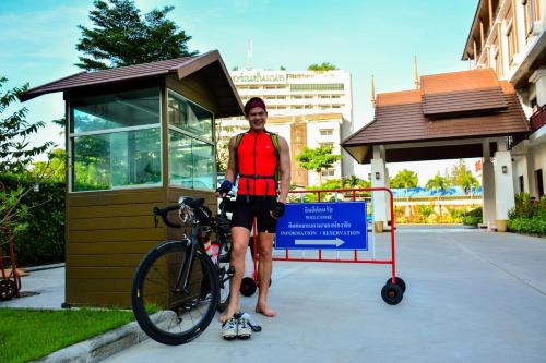a man standing next to a bike next to a building at The Choice Hotel - Adults Only in Bangkok