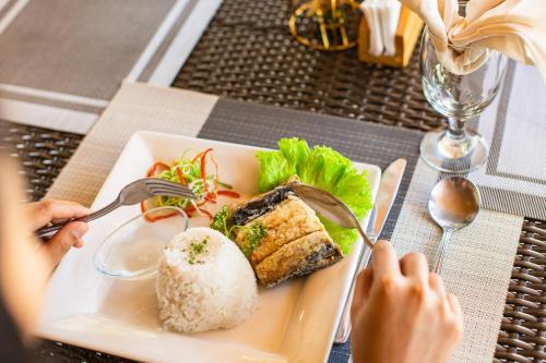 a person eating a plate of food with rice at Holiday Suites Puerto Princesa in Puerto Princesa City