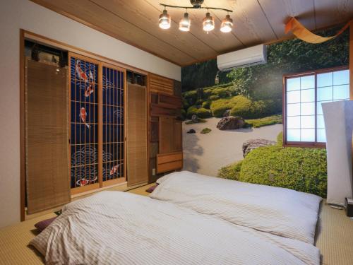 東京にあるComfort HASUNUMAのベッドと壁に絵が飾られた寝室