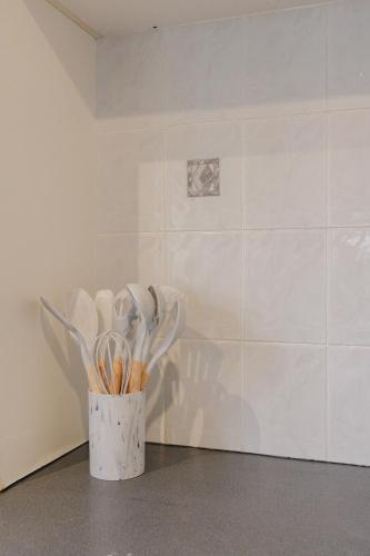 a vase filled with white utensils in a room at Prime location at Mt Eden- Cozy Vibe 3BR Home in Auckland