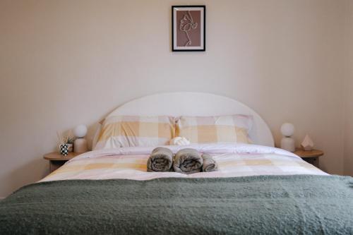 a pair of shoes sitting on top of a bed at Prime location at Mt Eden- Cozy Vibe 3BR Home in Auckland
