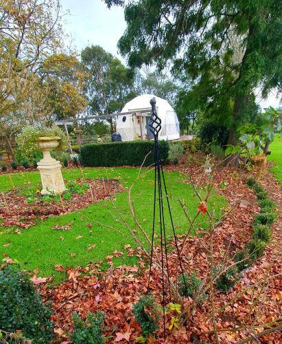 a garden with a greenhouse in the back yard at Counting Stars in Yarragon