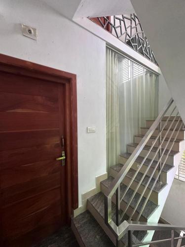 a stairway with a wooden door and a spiral staircase at DB Apartment Arimpur in Trichūr