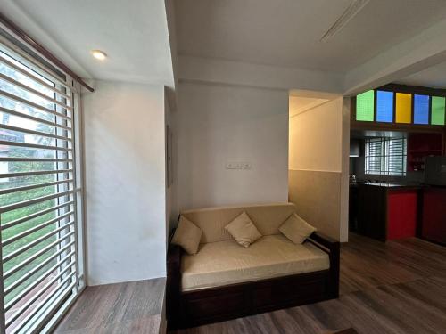 a living room with a couch and a window at DB Apartment Arimpur in Trichūr