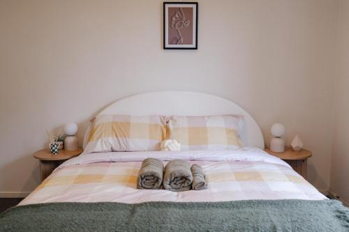 a pair of shoes sitting on a bed at Prime location at Mt Eden- Cozy Vibe 3BR Home in Auckland