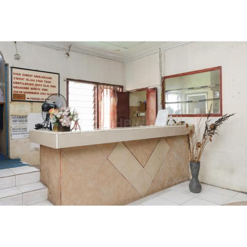 a counter in a restaurant with a mirror at Hotel Al Hakim Syariah Redpartner in Jakarta