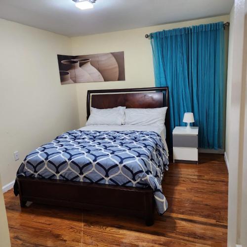 a bedroom with a bed and a blue curtain at Modern Comfort in Newark