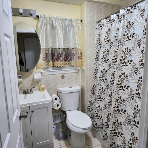 a bathroom with a toilet and a shower curtain at Modern Comfort in Newark