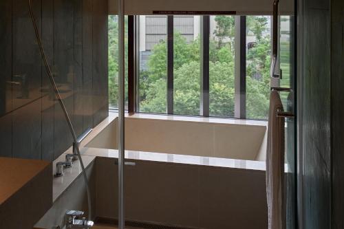a bathroom with a bath tub and a window at Hotel Royal Chiao Hsi in Jiaoxi