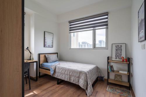 a bedroom with a bed and a window at Roomio Paris Hoang Kim-Shared Apartment in Ho Chi Minh City