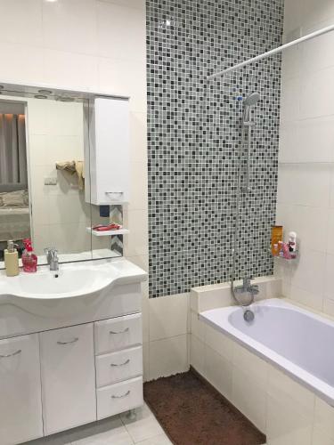 a bathroom with a sink and a tub and a mirror at Hanella's Place in Bacong