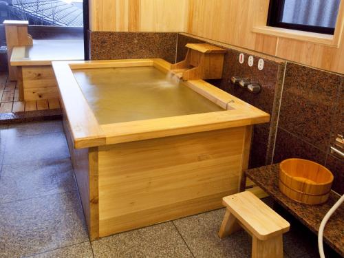 a large wooden bath tub in a bathroom at 徳の宿 ふぶ庵 in Beppu