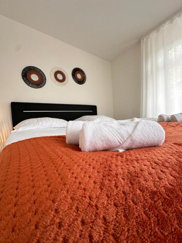 a bedroom with a bed with an orange blanket at AMAO Amber - 120 m2 Group Apartment - 10 Guests - King-Size Beds - 2 Bathrooms - Free Parking in Rheinhausen