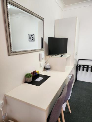 a white desk with two chairs and a mirror at Inverell Motel in Inverell