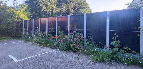 a fence with a bunch of flowers in a parking lot at Penthouse 40 m2 in Zemst
