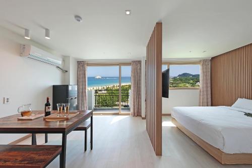 a bedroom with a bed and a table with wine glasses at Ocean 2 You Resort Seorak Beach Hotel & Condo in Sokcho