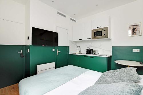 Cette chambre verte et blanche dispose d'un lit et d'une cuisine. dans l'établissement Beautiful Studio for 2P with A-C - Near Montmartre, à Paris