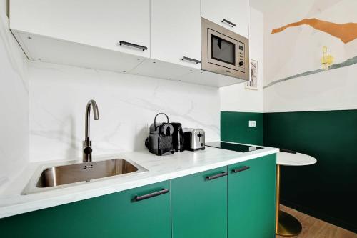 une cuisine avec des armoires vertes et un évier dans l'établissement Beautiful Studio for 2P with A-C - Near Montmartre, à Paris