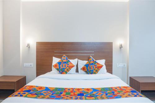 a bedroom with a large bed with colorful pillows at FabHotel Classic Executive in Phūrsungi