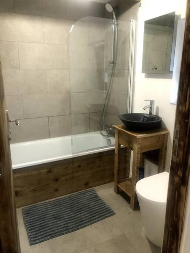 une salle de bain avec une baignoire, un lavabo et des toilettes dans l'établissement La Grangette Apartment B Great Location, à Morzine