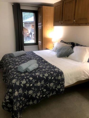 - une chambre avec un grand lit et une couverture noire et blanche dans l'établissement La Grangette Apartment B Great Location, à Morzine