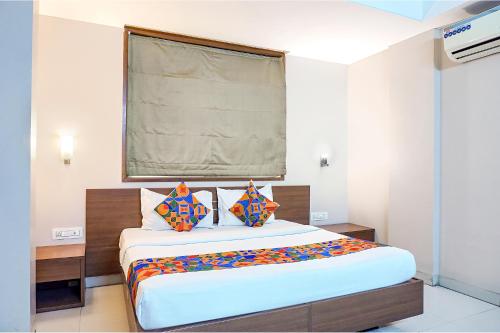 a bedroom with a large bed with colorful pillows at FabHotel Classic Executive in Phūrsungi