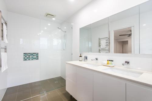 Un baño blanco con dos lavabos y una ducha. en Bliss And Harmony, en Gold Coast