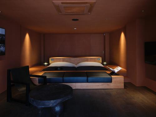 a bedroom with a bed with a couch and a chair at After Chapter Hotel Gwanganri in Busan