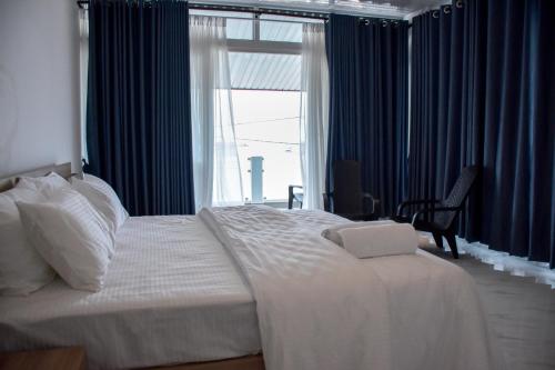a bedroom with a large white bed with a window at Trinco Caritas Guest Villa in Trincomalee