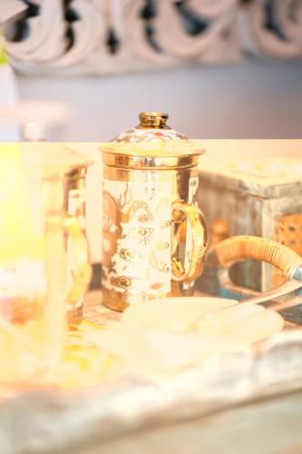 a gold jar sitting on top of a table at The Temi Bungalow South Sikkim in Namchi