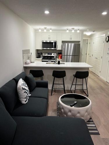 a living room with a couch and a kitchen at The Haven - cozy 1 bedroom suite in Seton SE Calgary in Calgary
