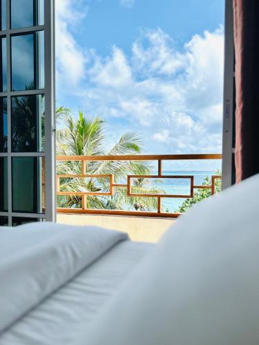 a bedroom with a view of the ocean from a balcony at Aqua Sunset in Gulhi