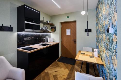 a small kitchen with a table and a microwave at GRANDIS Premium Apartments in Gödöllő