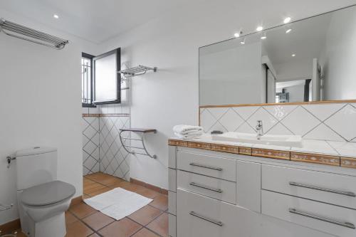 a white bathroom with a toilet and a sink at Villa Belle Etoile in Le Vauclin
