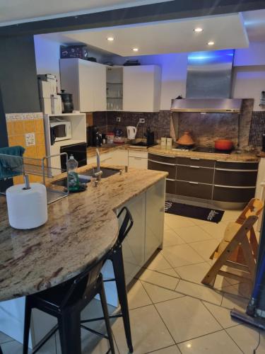 une grande cuisine avec une grande île au milieu dans l'établissement maison familiale très fonctionnelle, à Schwindratzheim