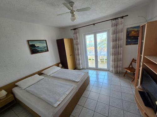 a bedroom with a bed and a large window at Apartment Stula in Omišalj