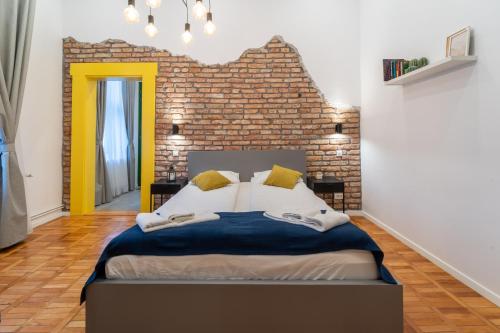 a bedroom with a large bed with a brick wall at 5 star Luxury Studio-Old Town Center in Cluj-Napoca