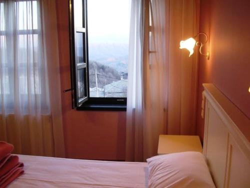 a bedroom with a bed and a window with a view at Hotel Monodendri in Monodendri