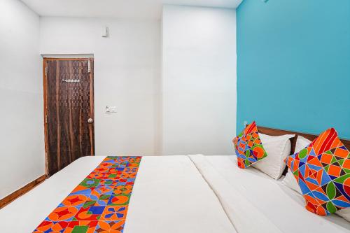 a bedroom with a bed with colorful pillows on it at Hotel RLV Green Palace - Nr Kengeri Satellite Town in Bengaluru
