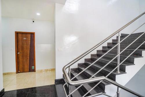 a staircase in a building with a wooden door at Hotel RLV Green Palace - Nr Kengeri Satellite Town in Bengaluru