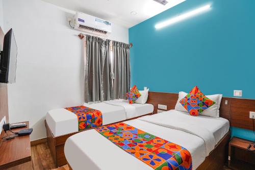 a room with two beds and a television at Hotel RLV Green Palace - Nr Kengeri Satellite Town in Bengaluru
