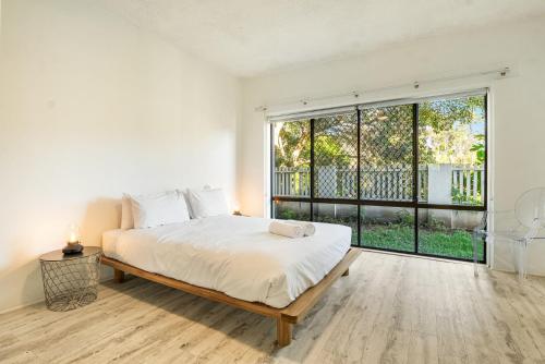 バイロンベイにあるBeachfront Beach Break 1 - Byron Bay Holiday Apartment with Pool, 3 Bedrooms, Beach Access & Parkingのベッドと大きな窓のある白い寝室