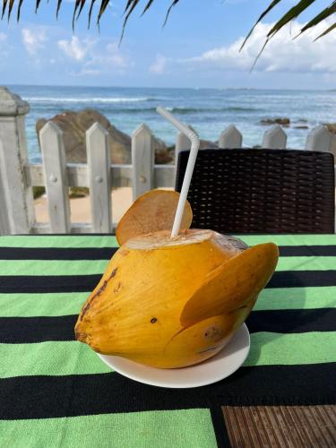 a banana on a plate on a table near the ocean at Happy Beach Resort in Unawatuna