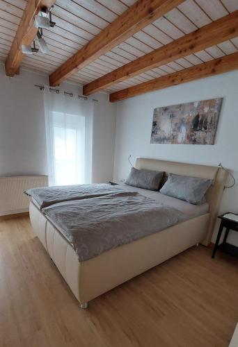 a bedroom with a large bed with a wooden ceiling at Fewo Höhbergblick in Tauberbischofsheim