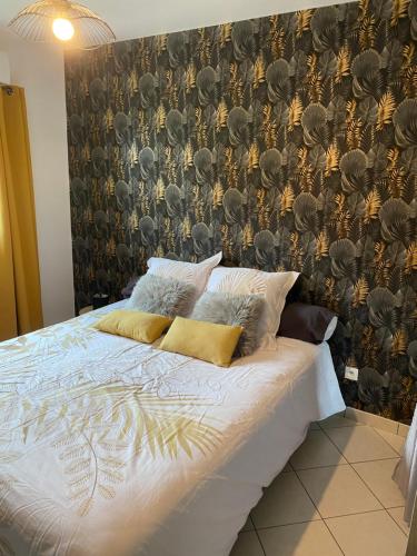 Ce lit se trouve dans une chambre dotée d'un mur avec du papier peint. dans l'établissement Gîte de la chapelle, à Landrethun-lès-Ardres