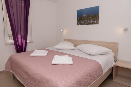 a bedroom with a bed with two towels on it at Stara Gavza 155 in Cres